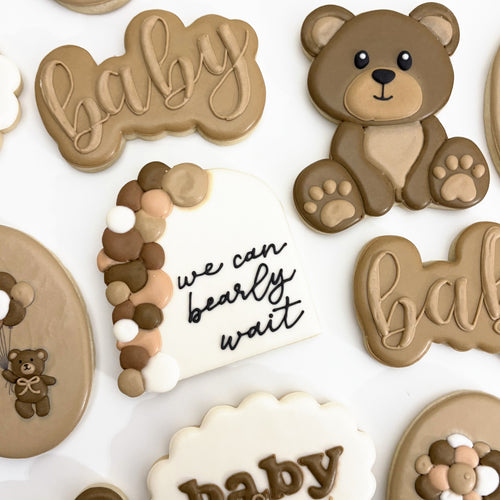 Baby shower cookies: a teddy bear, a we can bearly wait arch and baby script cookies in soft browns and cream