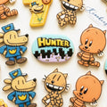 Comic book cookies: cartoon dog and cat characters in blue and orange with a personalised name plaque and a city skyline
